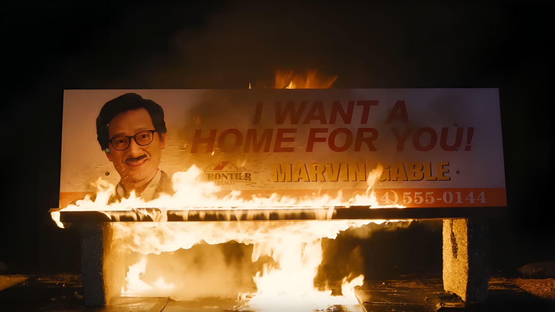 A burning billboard signals Marvin’s past catching up with him in Love Hurts. (Image via Universal Pictues)